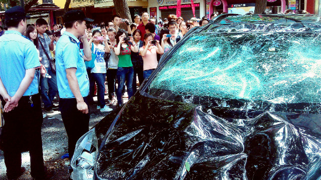 People take pictures of a Japanese car damaged during a protest against Japan&#39;s &#39;nationalizing&#39; of the disputed Diaoyu Islands, also known as Senkaku Islands in Japan, in the Chinese city of Xi&#39;an, on September 15, 2012. 