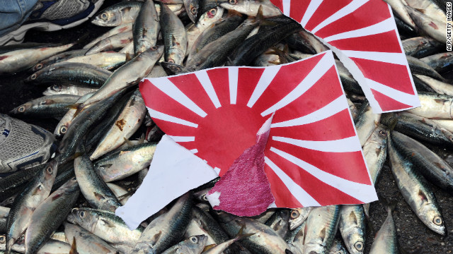 A torn apart Japanese &#39;Rising Sun&#39; flag is placed on dead fish during a demonstration in Taipei on September 14, 2010, over the disputed Senkaku/Diaoyu island chain.