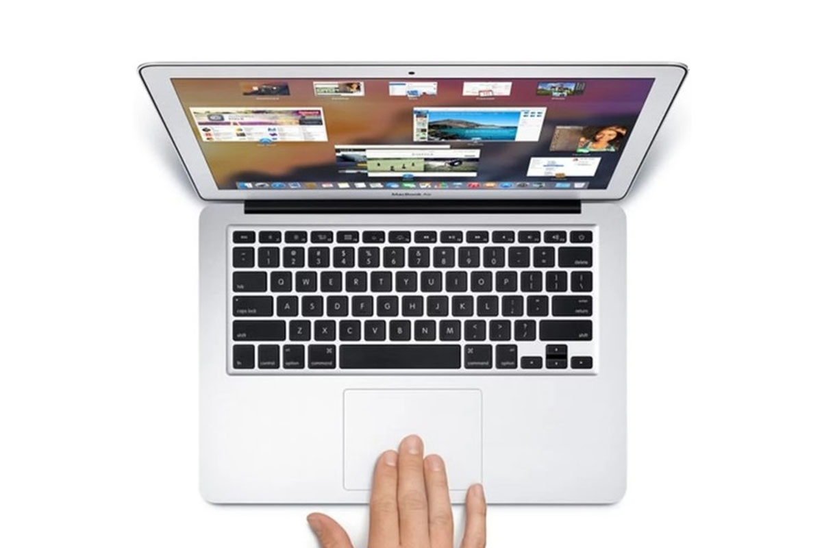 A MacBook Pro with a person using the touchpad