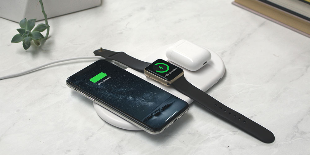 A charging pad, charging an iPhone, Apple Watch and AirPods