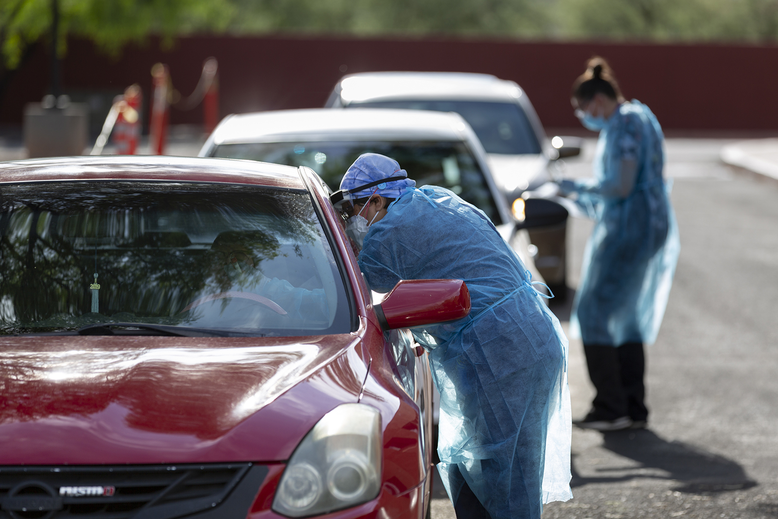 Healthcare workers wearing personal protective equipment (PPE) administer tests at a Covid-19 drive-thru testing site in Tucson, Arizona on July 13.