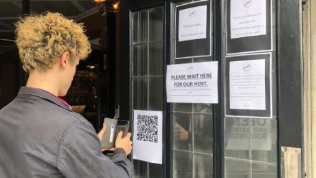 Plastic screens, tracings apps and table service. English pubs reopen on bittersweet day