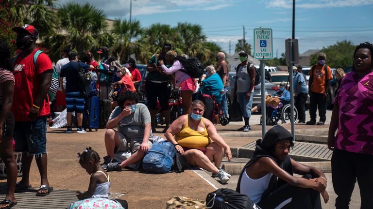 People wait to board a bus as residents evacuate ahead of Hurricane Laura in Galveston, Texas