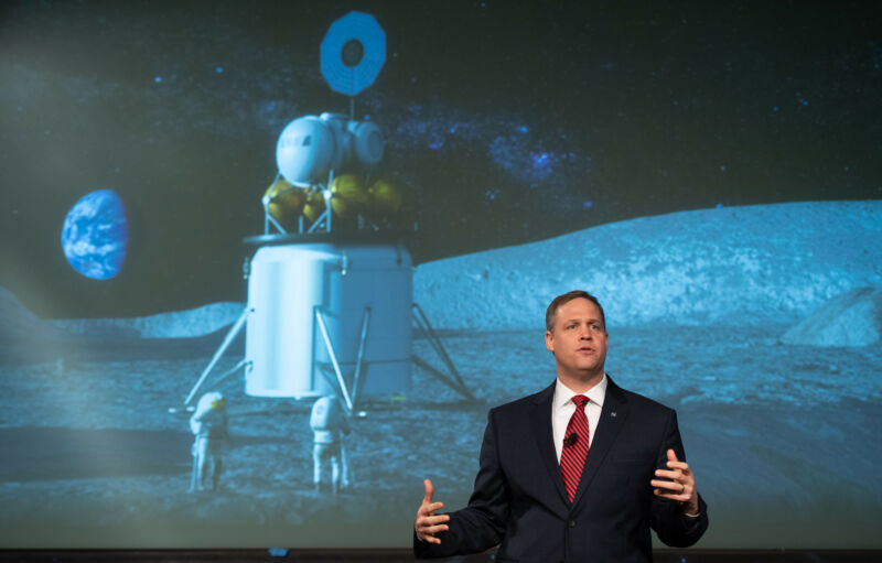 Someone in the suite speaks in front of a mural of the moon landing.