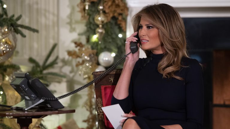 Mr Trump speaks on the phone while answering calls from people calling the Norad Santa Tracker phone line in 2018