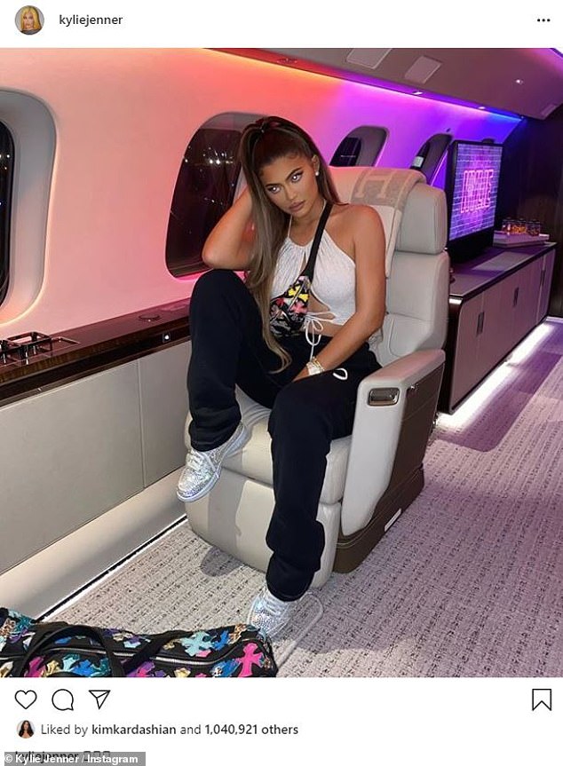 Jet setting: 23-year-old Kylie Jenner showed off her adequate cleavage and midriff in a white drawstring halter top while on a private plane on Saturday.