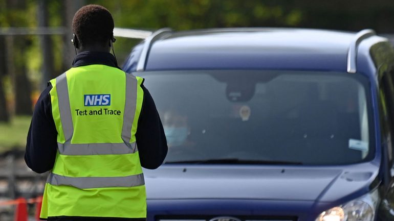 An NHS worker is seen wearing a Test and Trace jacket at Lee Valley Athletics Centre in Edmonton