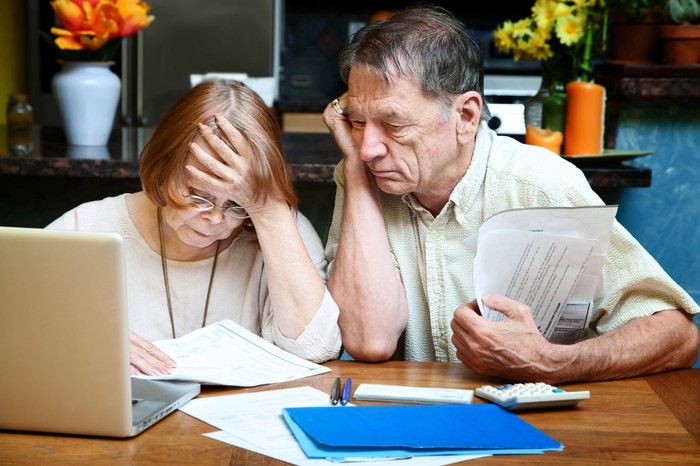 Anxious senior couple looking at financial records