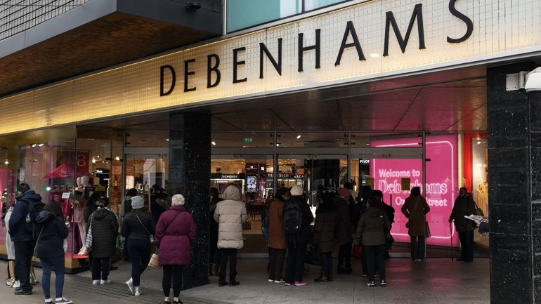 Shoppers queue outside Debenhams as it reopens after England's lockdown - a day after it revealed it was winding down 2/12/2020