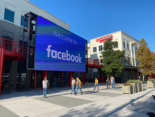 Funcionários do Facebook caminham pelo pátio do campus da empresa em Menlo Park,