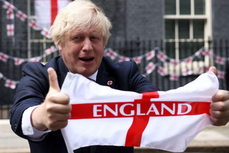Il premier britannico Boris Johnson sventola la bandiera inglese