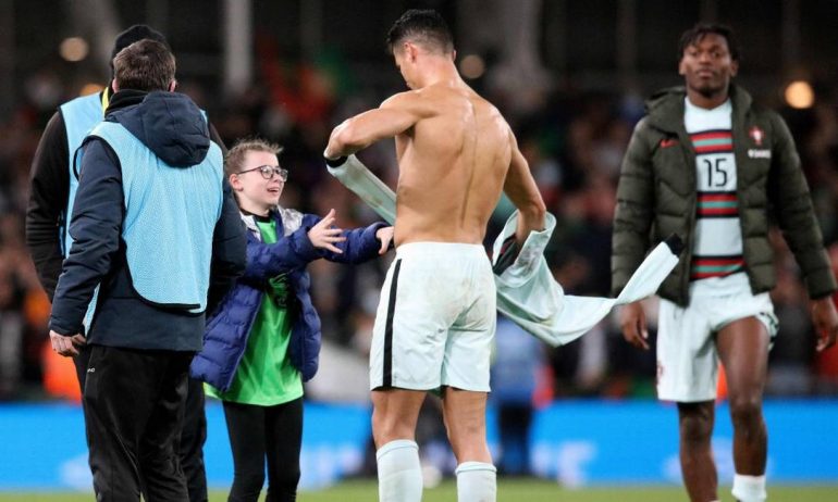 CR7 takes off his shirt and hands it to the girl who attacked the lawn Photo: Paul Faith / AFP