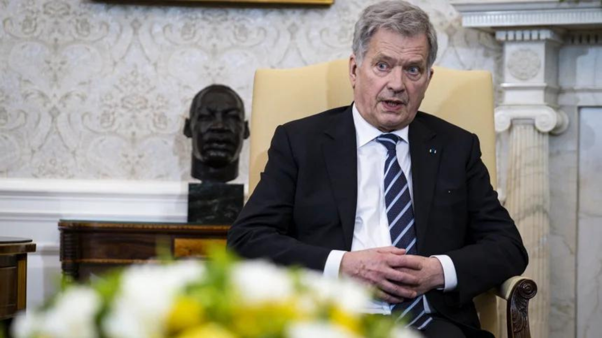 Finland's president says Putin does not want to change Ukrainian government  He sits in a chair, dressed in black and looks serious.