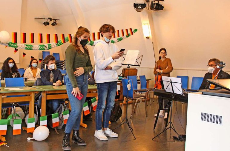 Die Kamera überträgt den Empfang live nach Lucan in Irland.  Julia Puchta und Jan Dlugos  begrüßen die Austauschschüler mit einer kleinen Rede und  Sina Zuber mit ihrer Geige. Schulleiter Gerd Koppitz (rechts) begleitete sie auf dem Keyboard.