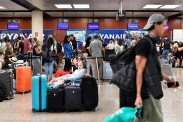 Des voyageurs attendent devant les comptoirs d&apos;enregistrement de la compagnie aérienne Ryanair, le 1er juillet 2022 à Barcelone (AFP/Archives - Pau BARRENA)