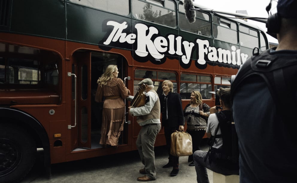 The Kellys board their bus with luggage and musical instruments